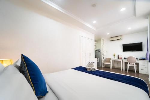 ホーチミン・シティにあるSabina Residence - HCMの白いベッドルーム(青い枕の大型ベッド付)