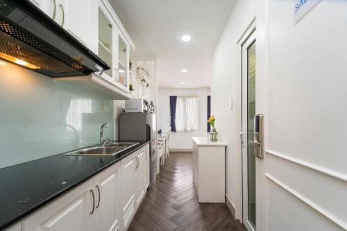 ホーチミン・シティにあるSabina Residence - HCMのシンクとカウンタートップのあるキッチン