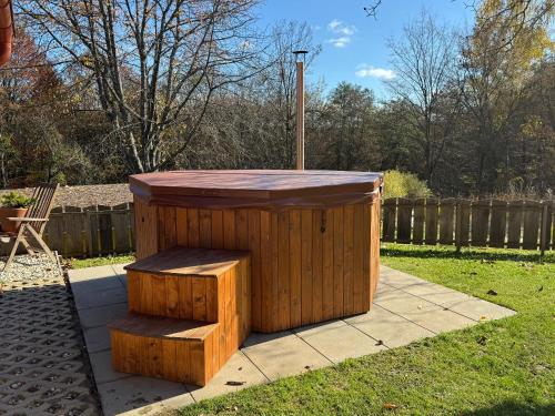 a wooden box with a bench in a yard at Frida Farm Vendégház in Kétvölgy