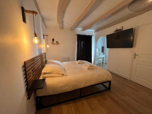 a bedroom with a large bed and a flat screen tv at Le Domaine des Songes in Saint-Maden