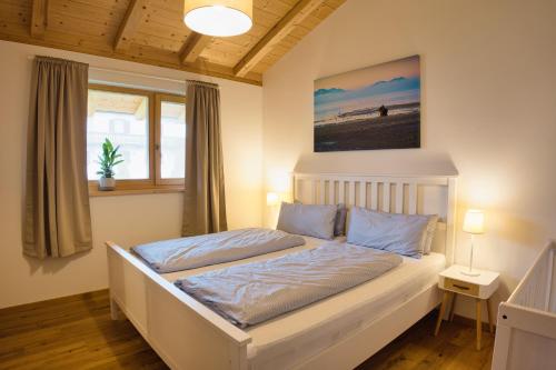 una camera da letto con un grande letto bianco con cuscini blu di Ferienwohnung Waldzeit a Staudach-Egerndach