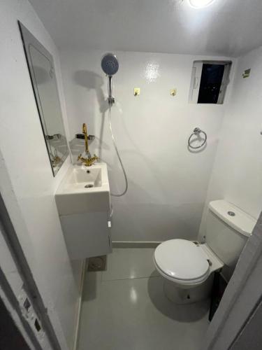 a white bathroom with a toilet and a sink at Assuan Felucca in Aswan