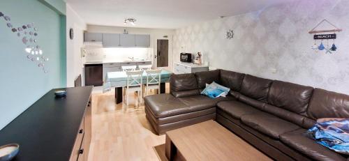 ブランケンベルヘにあるParadis Zeedijk 4のリビングルーム(ブラウンレザーのソファ付)、キッチン