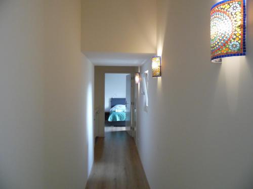 a hallway with a room with a bed and a chandelier at Cozy Bed and Breakfast in Elst