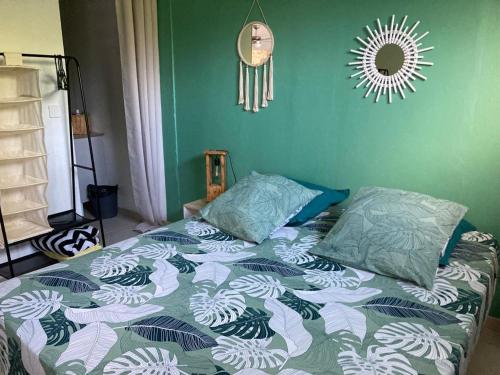 uma cama com um edredão e almofadas num quarto em Appartement 2 personnes em Rivière-Salée