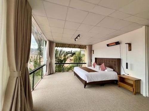 a bedroom with a bed and a large window at Casa Encuentro San Blas in Cusco