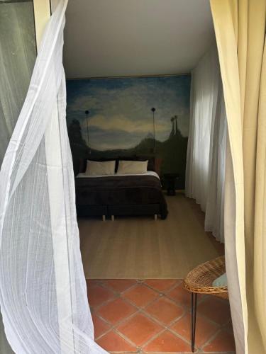 a bedroom with a bed and a painting on the wall at Suite Vigia Jardim in Jardim do Mar