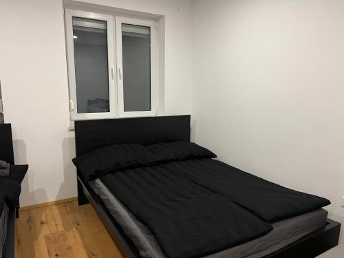 Una cama en una habitación blanca con ventana. en Cozy City Center Designer Apartment for 10 People, en Wiener Neustadt