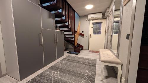 ein Flur mit einer Treppe, einer Bank und einem Teppich in der Unterkunft Svedjan Escape Villa in Hedemora