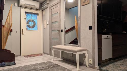 Ein Zimmer mit einem Hocker und einer Tür mit einem Spiegel in der Unterkunft Svedjan Escape Villa in Hedemora
