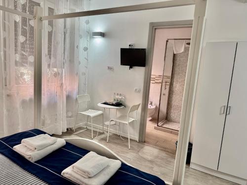 een slaapkamer met een bed, een tafel en een spiegel bij Residenza Borgo Trento SUNDAY in Verona