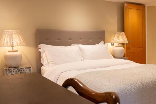 una camera da letto con un grande letto bianco con due lampade di Garden flat a Bath
