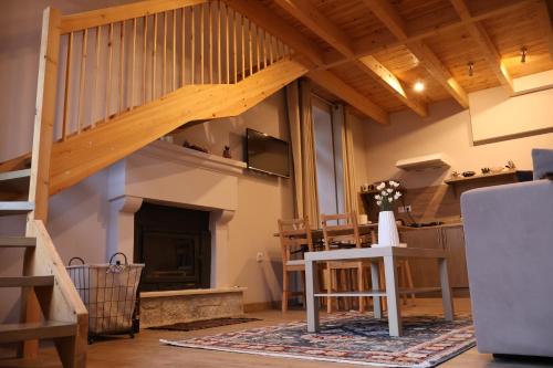 uma sala de estar com uma escada de madeira e uma mesa em Δρυάδες Suites em Arachova