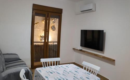 een woonkamer met een tafel en een tv bij Luna del este in Peñíscola