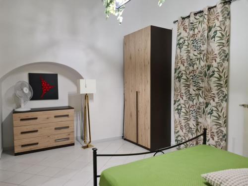 una camera da letto con un letto e un comò e un comò con un vestito di Casa Kikko a Mattinata