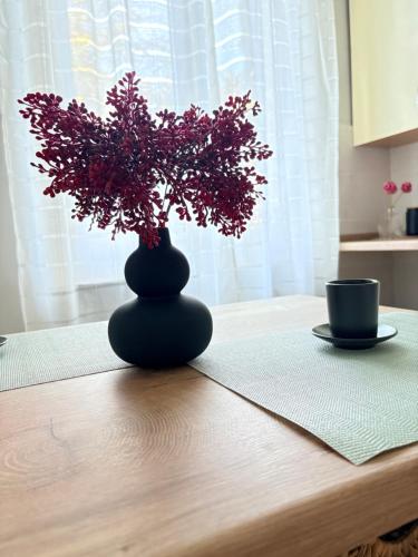 een zwarte vaas op een tafel met een plant bij Oltre le mura in Montefalco