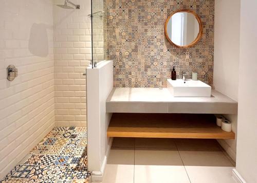 a bathroom with a sink and a mirror at Kana Vista in Plettenberg Bay