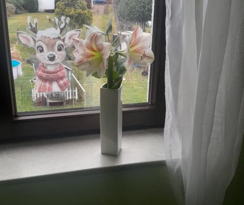 a vase with flowers sitting on a window sill at Taurasteinblick in Burgstaedt