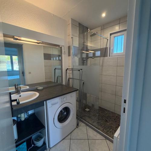 Un baño con lavadora y lavabo. en Maison de vacances 3 étoiles - Sous les Pins, en Ozillac