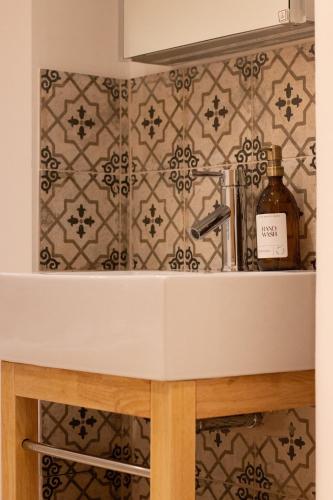 a kitchen with a sink and a wall with tiles at Garden flat in Bath