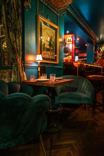 Un bar con sillas verdes y una mesa en una habitación. en Caboose, en Salisbury