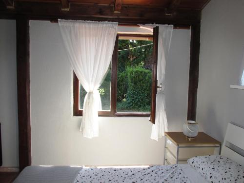 a bedroom with a bed and a window with curtains at Private house with car park at nemi lake 