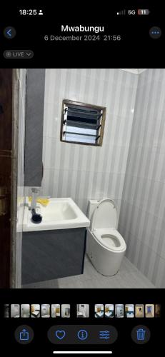 a bathroom with a toilet and a sink at Wrens cosy home in Diani Beach