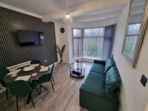 a living room with a green couch and a table at Brand new modern and stylish 2 bedroom apartment in Sheffield