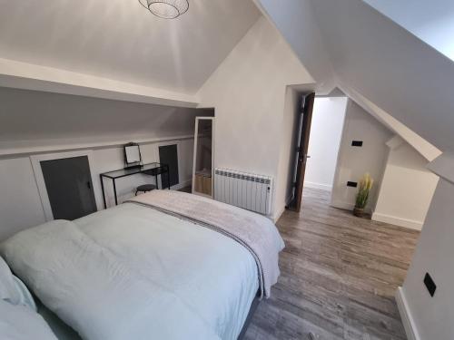 a bedroom with a white bed and a staircase at Brand new modern and stylish 2 bedroom apartment in Sheffield