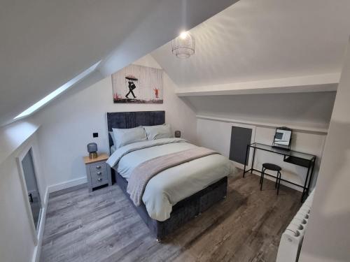 a bedroom with a large bed and a desk at Brand new modern and stylish 2 bedroom apartment in Sheffield