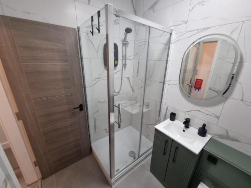 a bathroom with a shower and a sink and a mirror at Brand new modern and stylish 2 bedroom apartment in Sheffield
