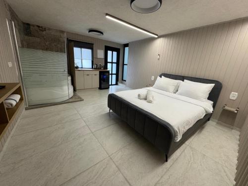 a bedroom with a large bed and a bathroom at רויאל דליה in Dāliyat el Karmil