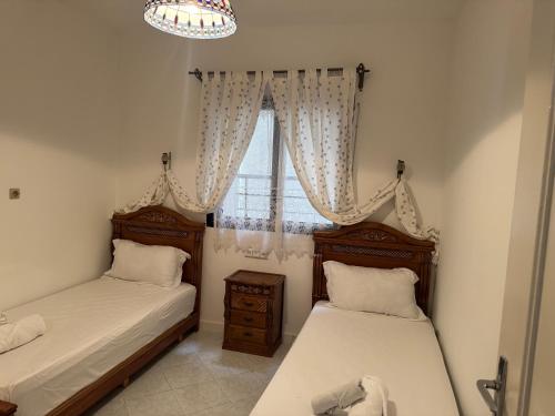 丹吉尔1 Minute from Beach, Sea View Apartment in Tangier city centre的一间卧室设有两张床和一个带吊灯的窗户。