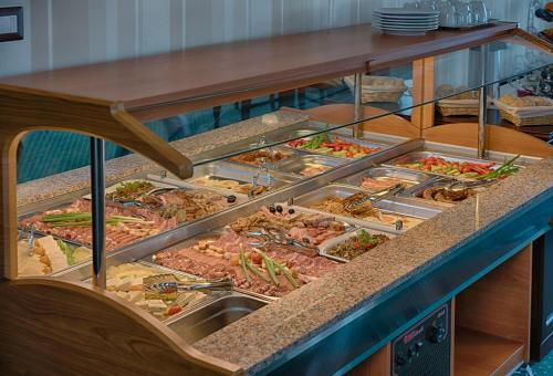 a buffet filled with lots of different types of food at Magus Hotel in Baia Mare