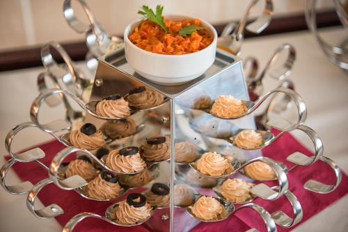 a tray of cupcakes on a table with a bowl of food at Magus Hotel in Baia Mare