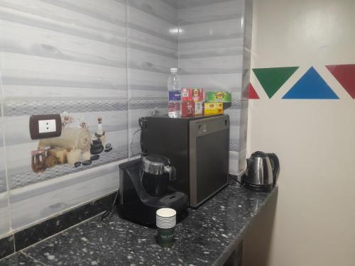 Una cocina con una encimera y una cafetera encima. en Ounaty, en Abu Simbel