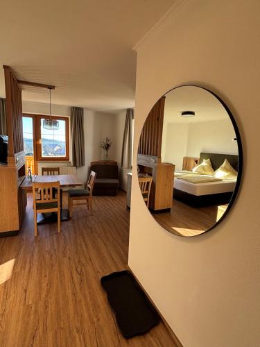 a room with a mirror and a living room with a bed at Landhotel Bärnriegel in Mauth