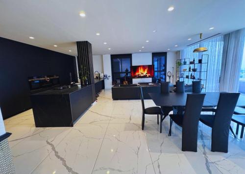 una cucina e una sala da pranzo con tavolo e camino di Sky High 15 - Luxury Penthouse with Panoramic View a Beer Sheva