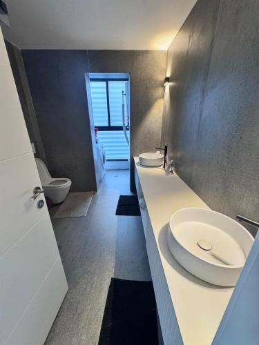 a bathroom with two sinks and a toilet at Sky High 15 Choose Between 2 Luxury Penthouses in Beer Sheva
