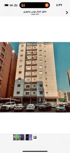 Un edificio alto con coches aparcados en un estacionamiento. en ماي سويت, en Kuwait
