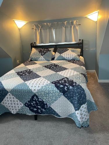 a bedroom with a bed with a quilt on it at Ardan Cottage in Ingonish in Ingonish Beach