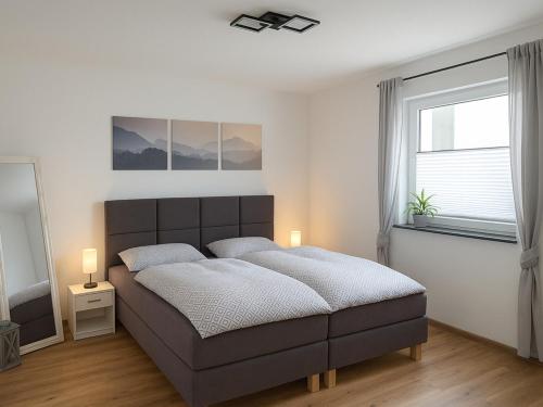 M&M AusZeit im Schwabenländle في Winterlingen: غرفة نوم بسرير كبير ونافذة