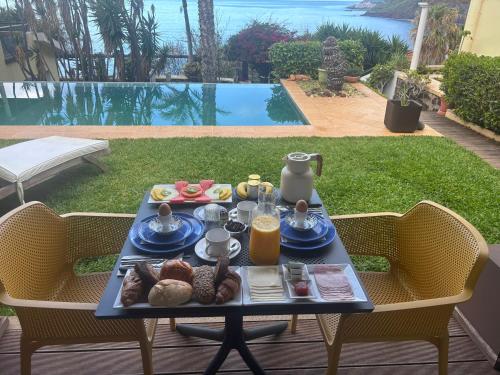 a tray of food on a table on a patio at Suite Vigia Jardim in Jardim do Mar