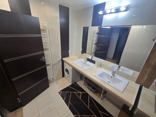 a bathroom with two sinks and a large mirror at Apartman Nina in Donovaly