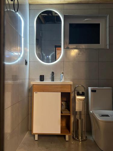 een badkamer met een wastafel en een spiegel en een toilet bij M Town cotagge house 