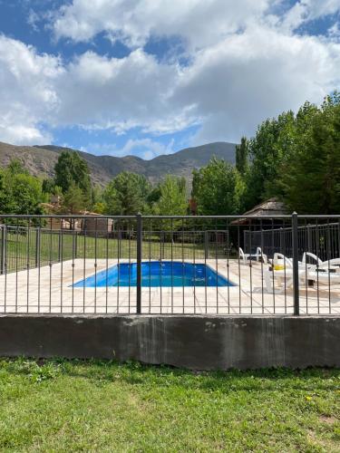 einen Zaun um einen Pool im Hof in der Unterkunft Cabañas Las Carditas in Mendoza