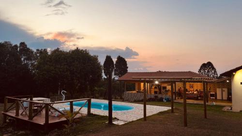 een huis met een zwembad in een tuin bij Chácara pôr do sol in Sorocaba
