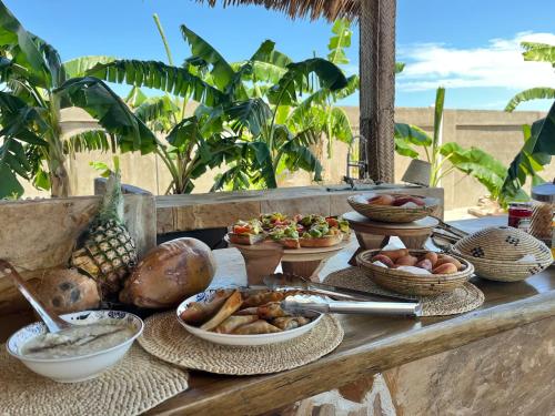 een buffet van eten op een tafel met kommen eten bij Villa Papaya in Jomba