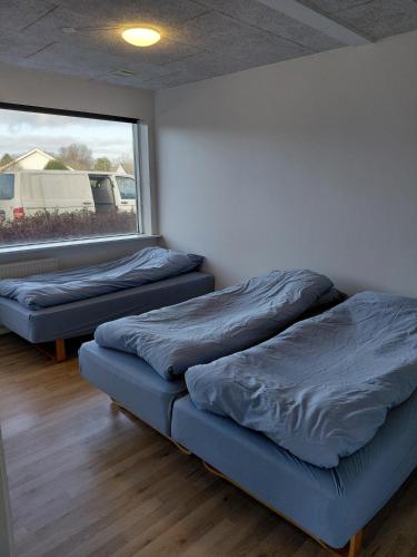 two beds sitting in a room with a window at Apartment in green area in Grindsted