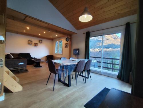 a living room with a table and chairs and a large window at Chalet Mustang Vallée in Laruns